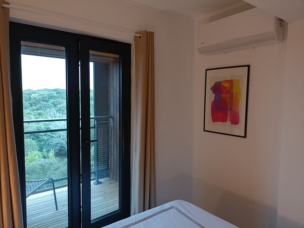 Chambre avec un tableau et la porte fenêtre vers le balcon - Appartement Le 308 Corse Pianottolli